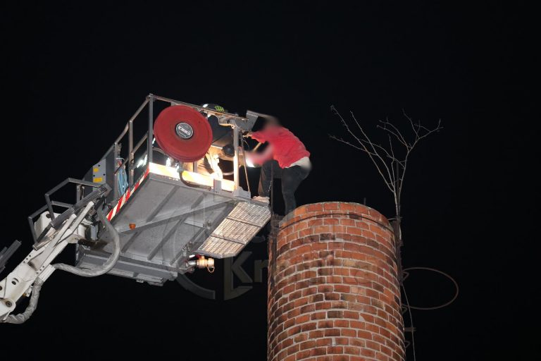 Egy ember felmászott egy régi gyárkémény tetejére